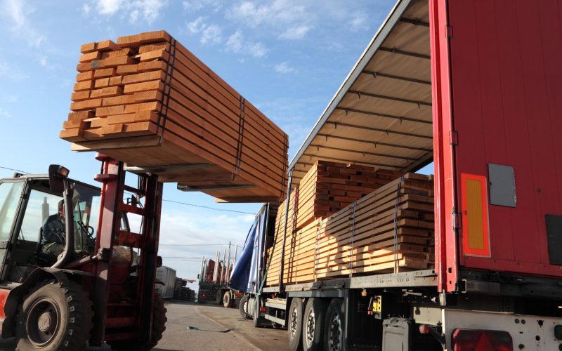 Forklift loading stacks of beech boards on a truck.